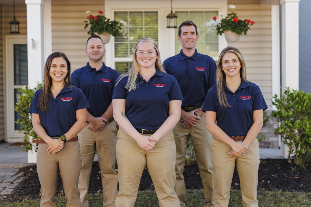 trutech technicians posing in front of a home
