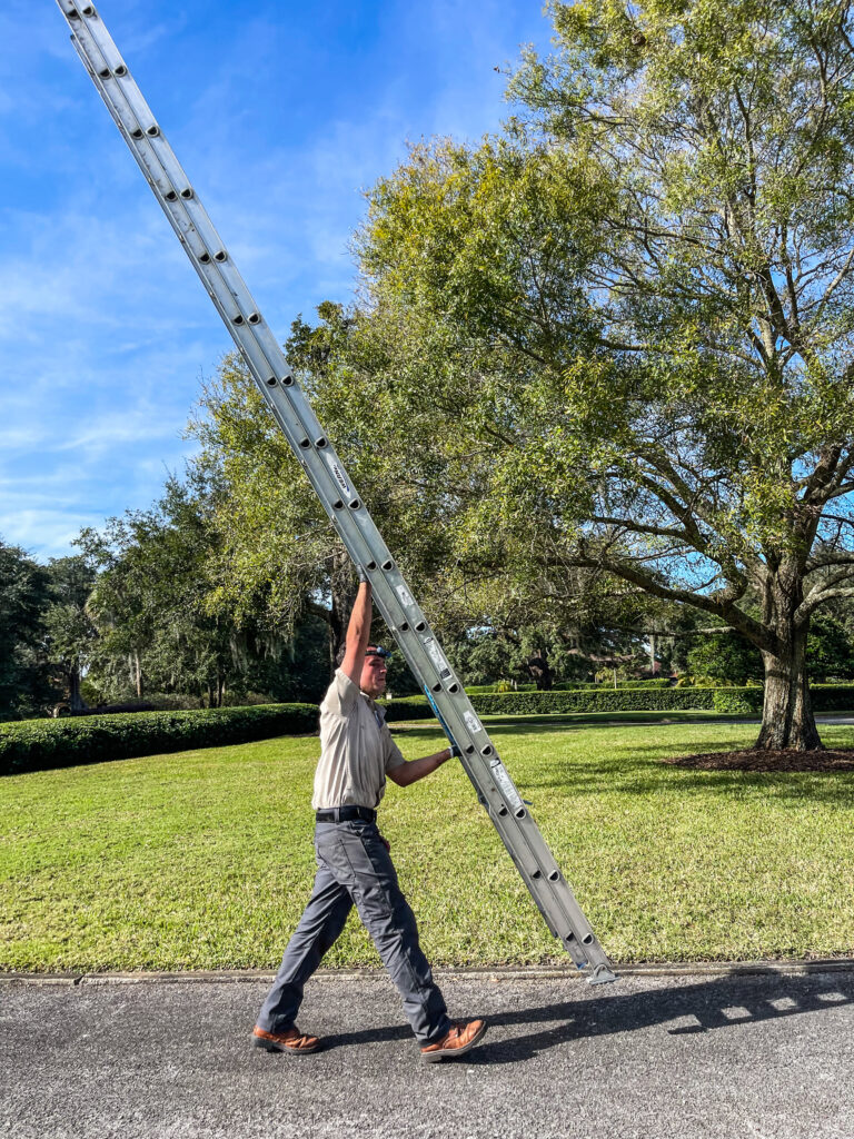 trutech technician approaching a customers home with a ladder